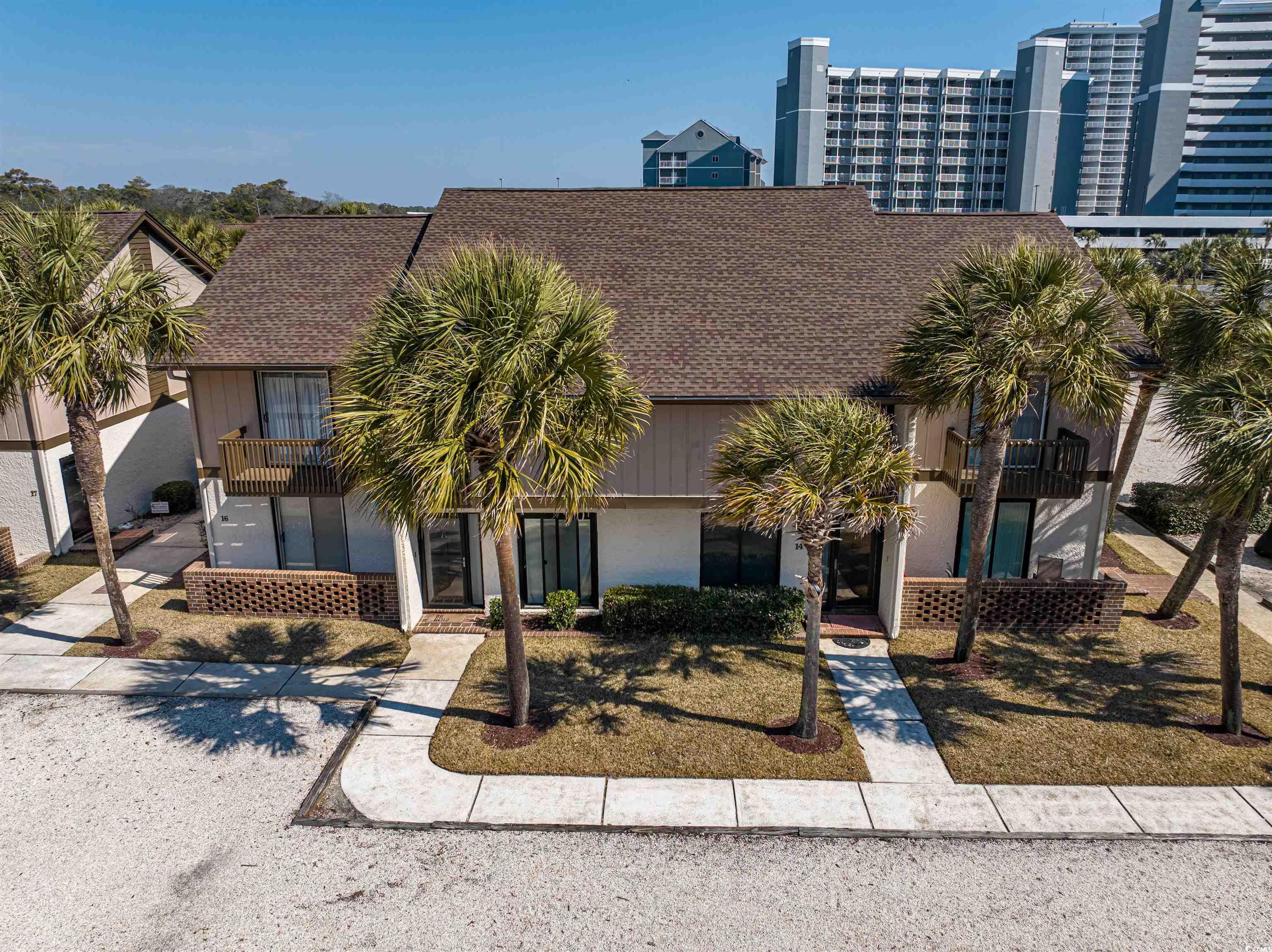 10200 Lakeshore Drive, Unit 16 Myrtle Beach, SC 29572 - Photo 2 of 36 View of front of property featuring a shingled roof and stucco siding
