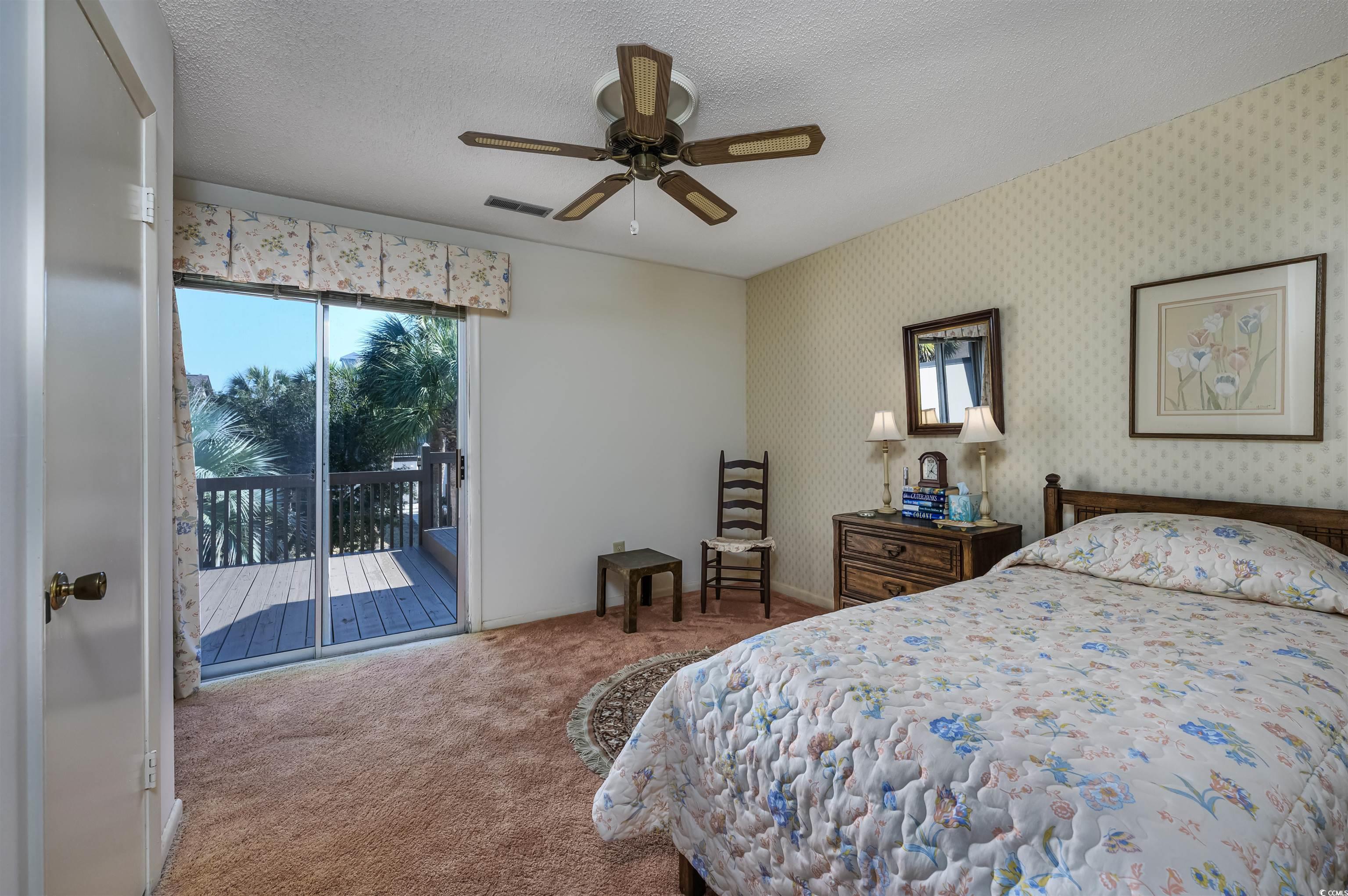 10200 Lakeshore Drive, Unit 16 Myrtle Beach, SC 29572 - Photo 27 of 36 Carpeted bedroom featuring wallpapered walls, visible vents, a ceiling fan, access to exterior, and a textured ceiling