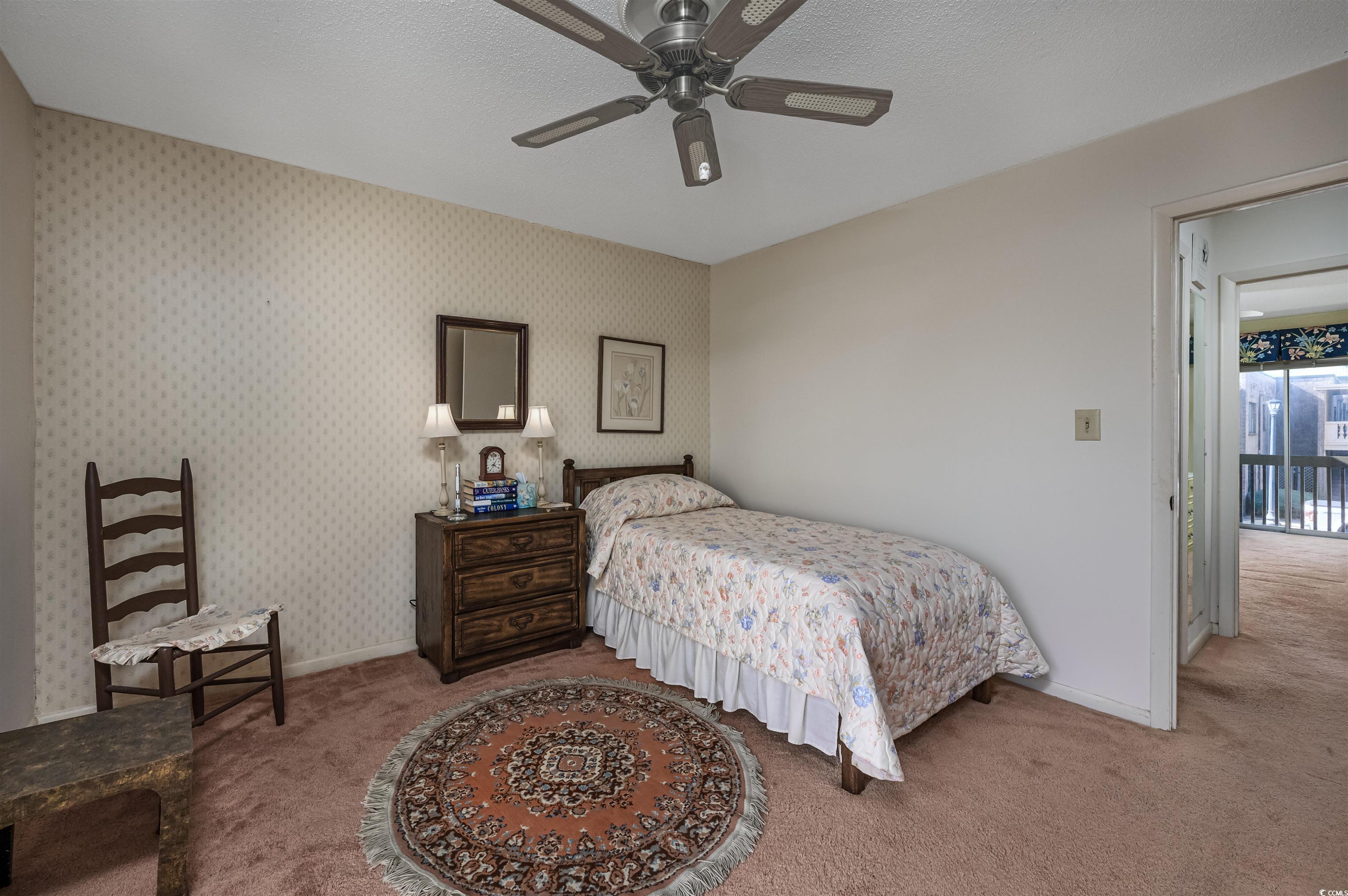 10200 Lakeshore Drive, Unit 16 Myrtle Beach, SC 29572 - Photo 28 of 36 Carpeted bedroom with a ceiling fan, a textured ceiling, baseboards, and wallpapered walls