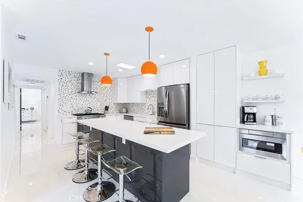 a kitchen with white cabinets and appliances