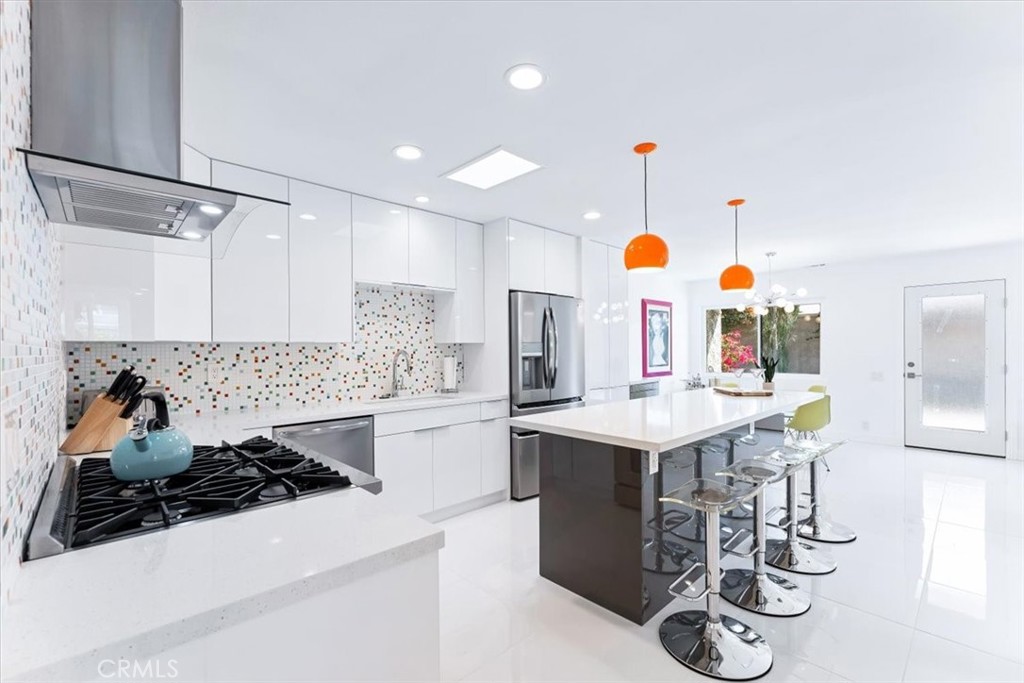 1111 Ramon Road, Unit 87 Palm Springs, CA 92264 - Photo 17 of 54 a kitchen with a sink a stove and chairs