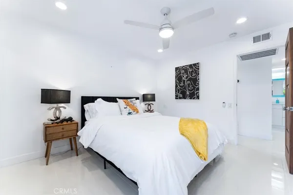 a bedroom with a bed and a painting on the wall