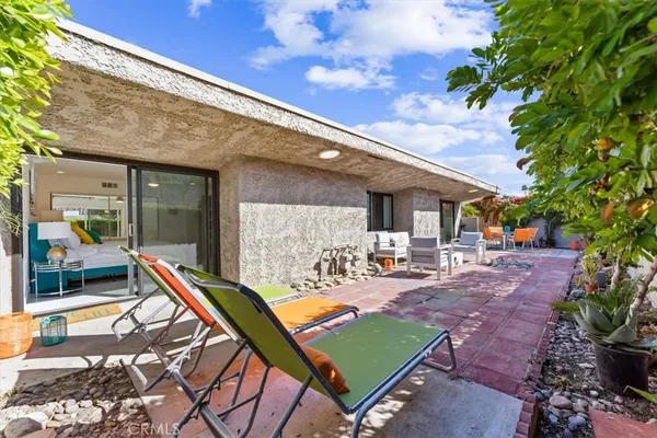 a view of a patio with couches table and chairs with potted plants