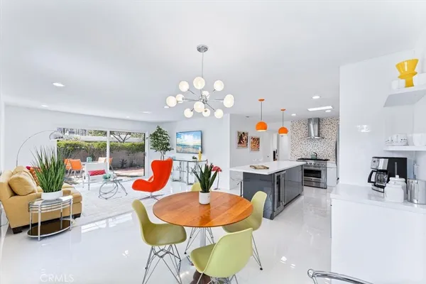 a living room with dining table and a chandelier