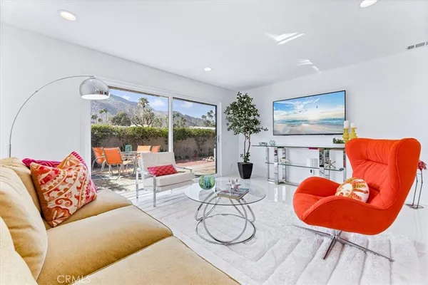a living room with furniture a rug and a large window