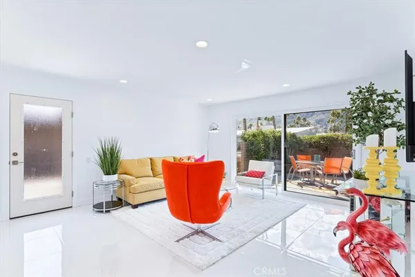 a living room with patio furniture and a potted plant