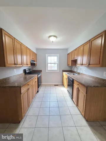 a large kitchen with stainless steel appliances granite countertop a stove a sink dishwasher and cabinets with wooden floor