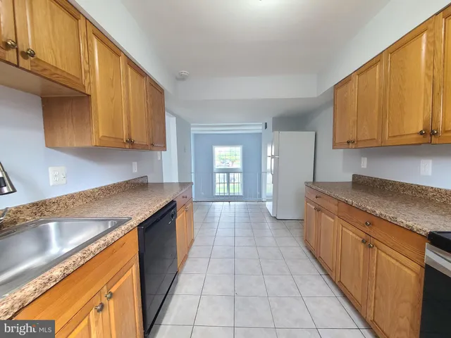 a kitchen with stainless steel appliances granite countertop a sink counter space cabinets and a window