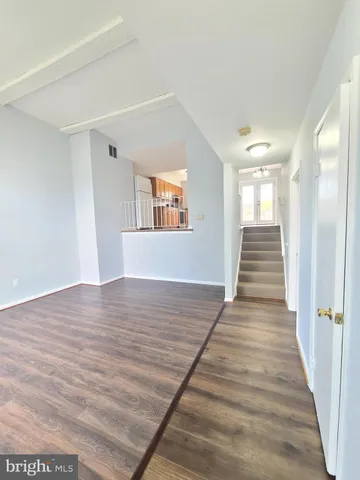 a view of a hallway with wooden floor and staircase
