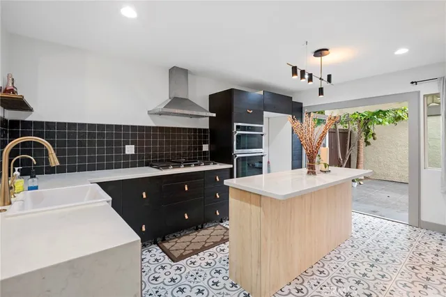 a kitchen with stainless steel appliances kitchen island granite countertop a stove a sink and a microwave