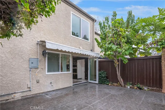a view of backyard with potted plants and wooden fence