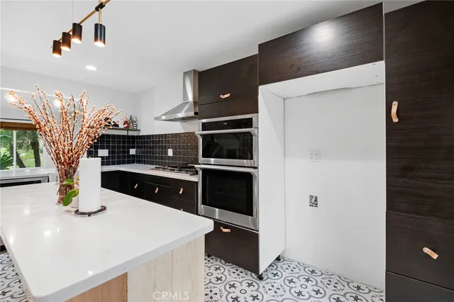 a kitchen with stainless steel appliances kitchen island granite countertop a refrigerator and a sink