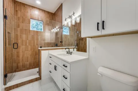 a bathroom with a sink a toilet and shower