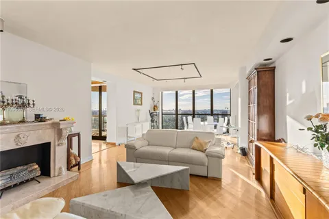 a view of a living room with furniture and floor to ceiling windows