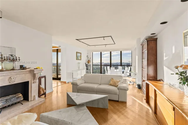 a view of a living room with furniture and floor to ceiling windows