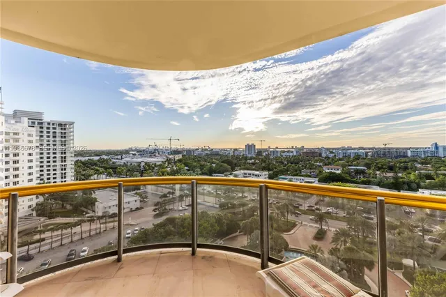 a view of a city from a balcony with seating space