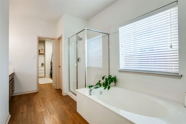 a bathroom with a tub shower and window