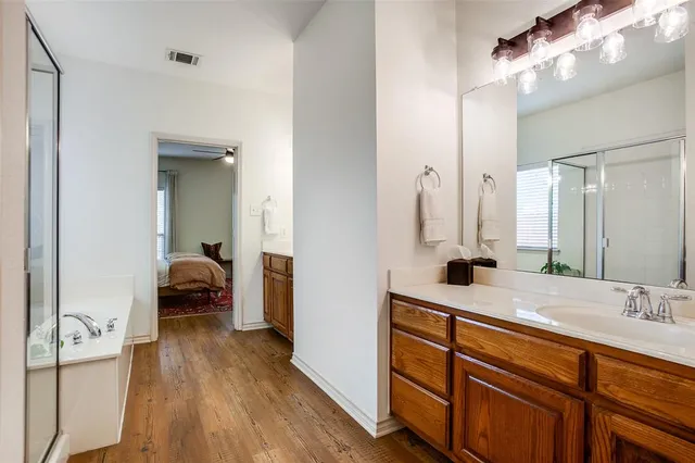 a en suite bathroom with a granite countertop sink and a mirror