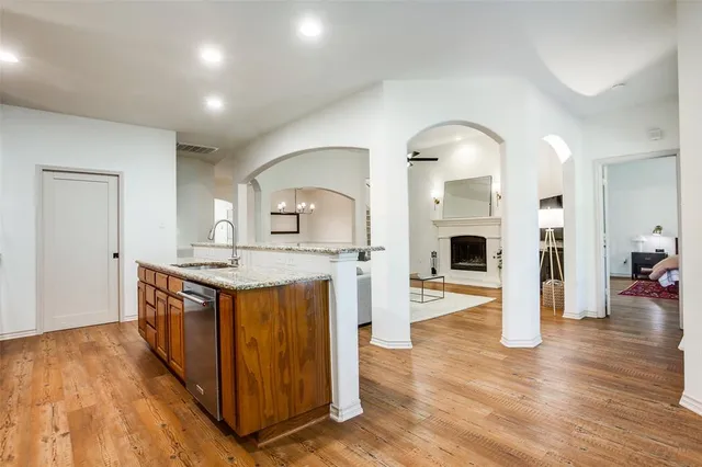 a kitchen with stainless steel appliances granite countertop a stove and wooden floor