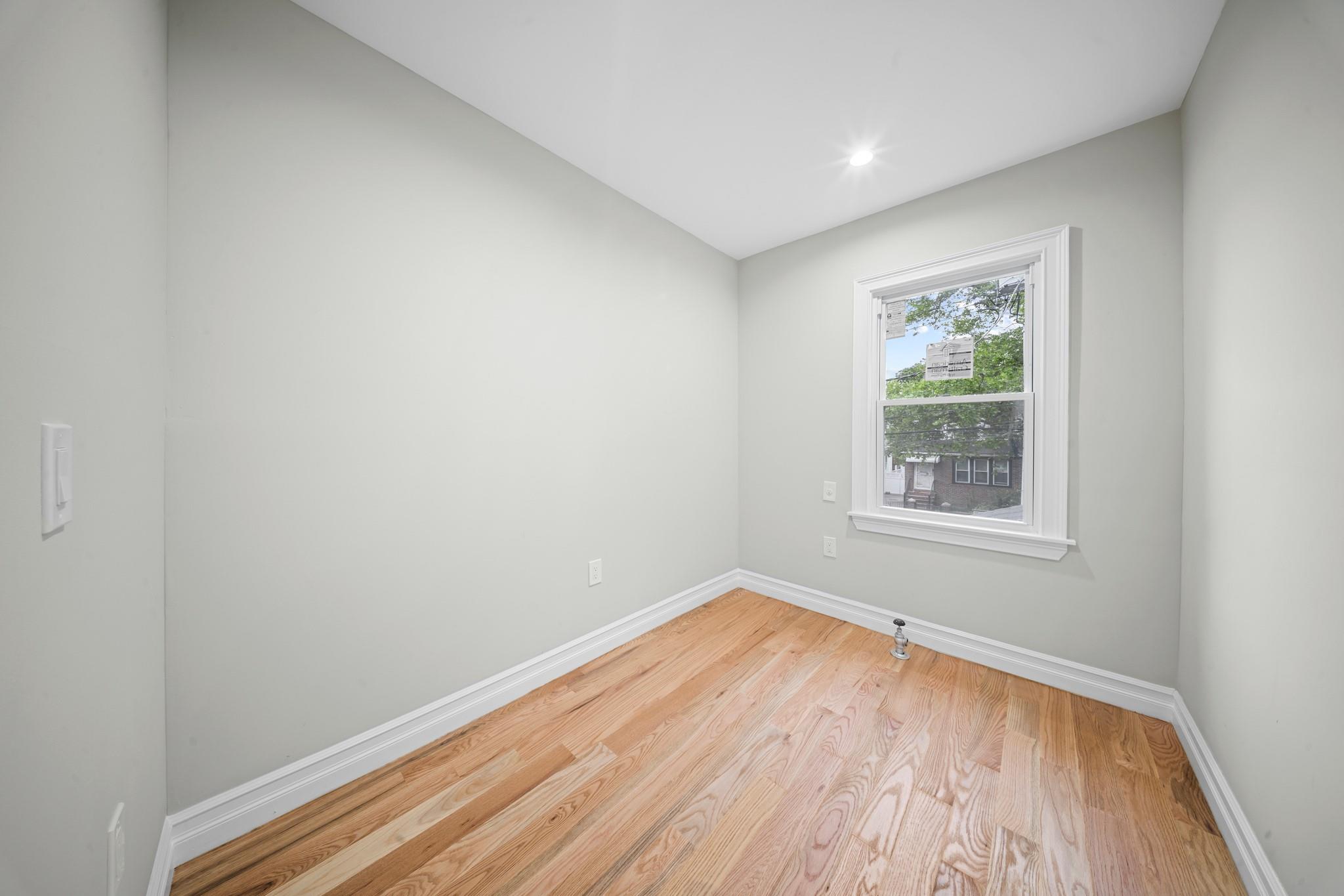 110-28 213th Street Queens, NY 11429 - Photo 12 of 22 Spare room with light wood-style flooring and baseboards