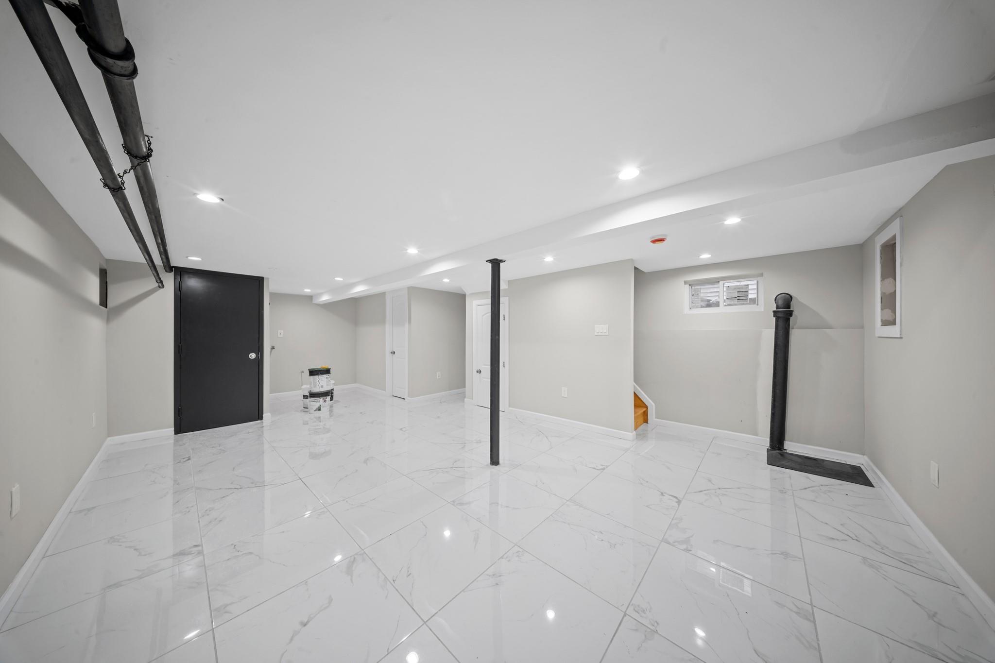 110-28 213th Street Queens, NY 11429 - Photo 14 of 22 Finished basement featuring stairway, recessed lighting, baseboards, and light marble finish floors