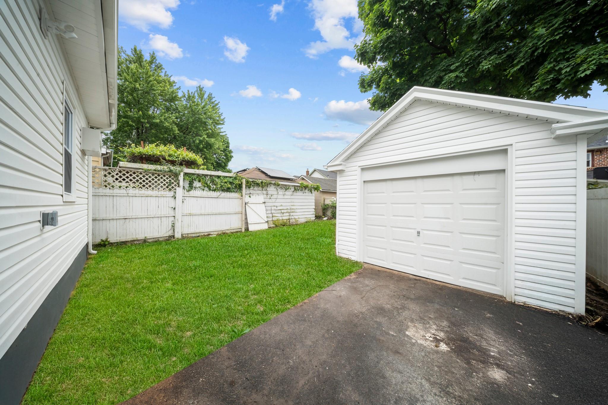 110-28 213th Street Queens, NY 11429 - Photo 17 of 22 View of yard featuring an outdoor structure, driveway, and a garage