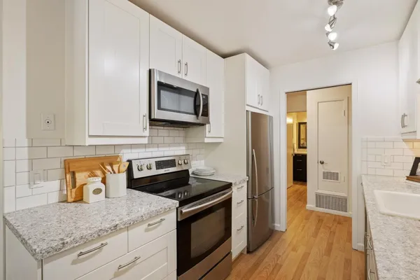 a kitchen with stainless steel appliances granite countertop a stove microwave and refrigerator