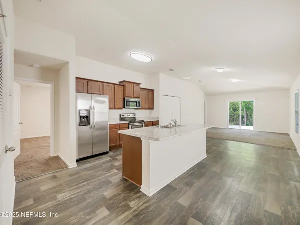 a view of kitchen with refrigerator and microwave