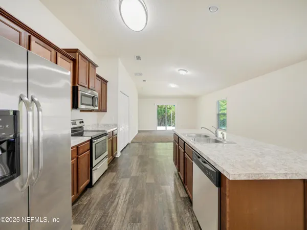 a kitchen with granite countertop a sink and stainless steel appliances