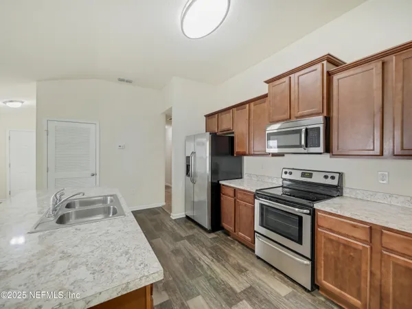 a kitchen with stainless steel appliances granite countertop a sink stove microwave and refrigerator