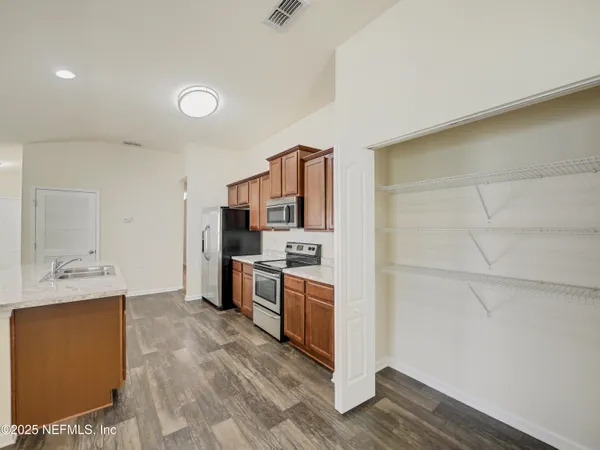 a large kitchen with cabinets and stainless steel appliances