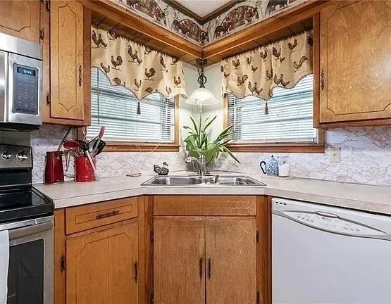 501 West College Street Rising Star, TX 76471 - Photo 11 of 17 a kitchen with stainless steel appliances granite countertop a sink a stove and cabinets