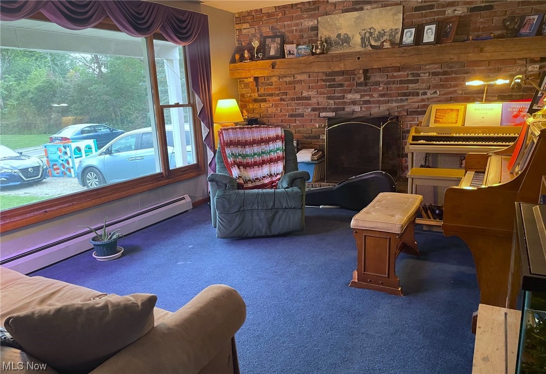 7297 Anderson Road Windham, OH 44288 - Photo 3 of 22 Carpeted living room featuring brick wall and a baseboard heating unit
