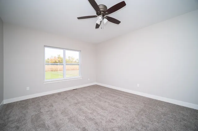 an empty room with a window and a fan