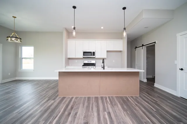 an open kitchen with kitchen island and stainless steel appliances