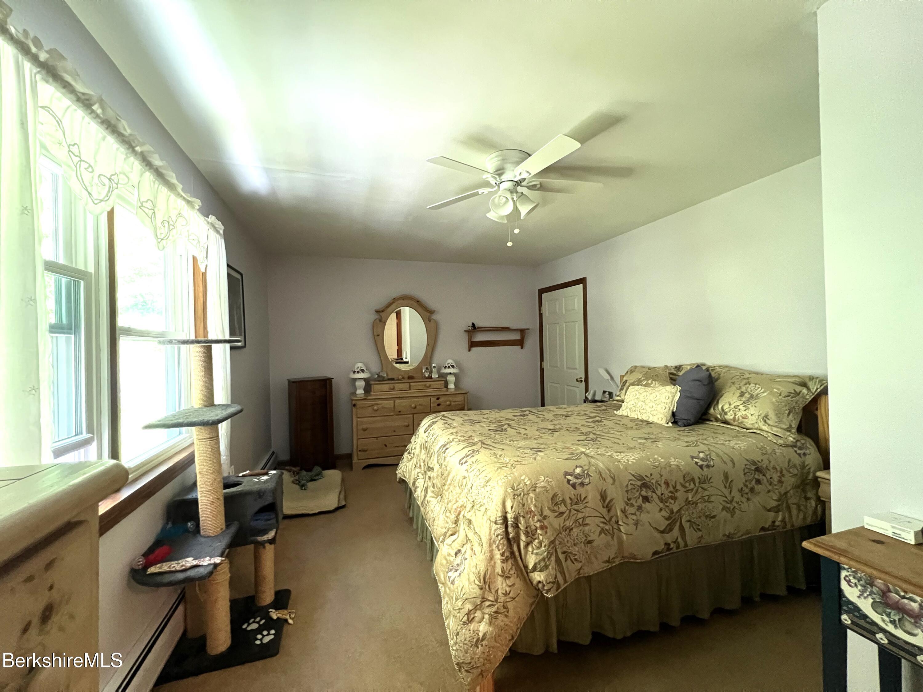 215 Partridge Road Pittsfield, MA 01201 - Photo 30 of 38 a bedroom with a bed a chandelier and a dresser next to a window