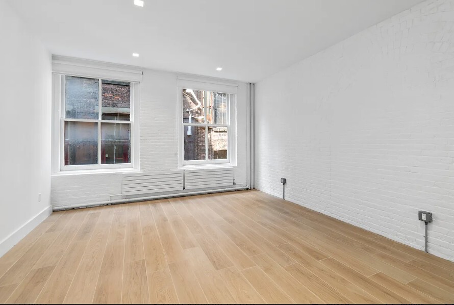 160 Franklin Street, Unit 5 Manhattan, NY 10013 - Photo 4 of 12 a view of an empty room with a window and wooden floor