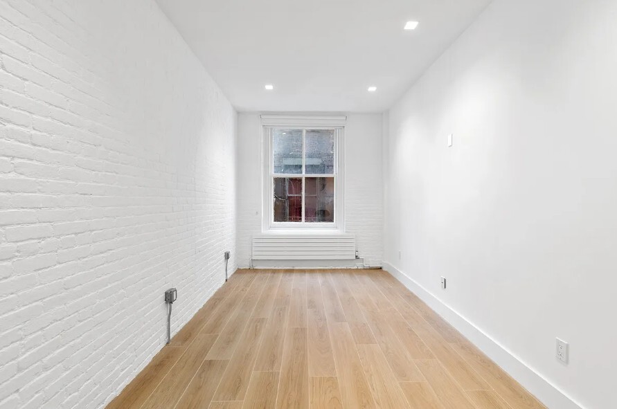 160 Franklin Street, Unit 5 Manhattan, NY 10013 - Photo 6 of 12 a view of empty room with wooden floor and fan