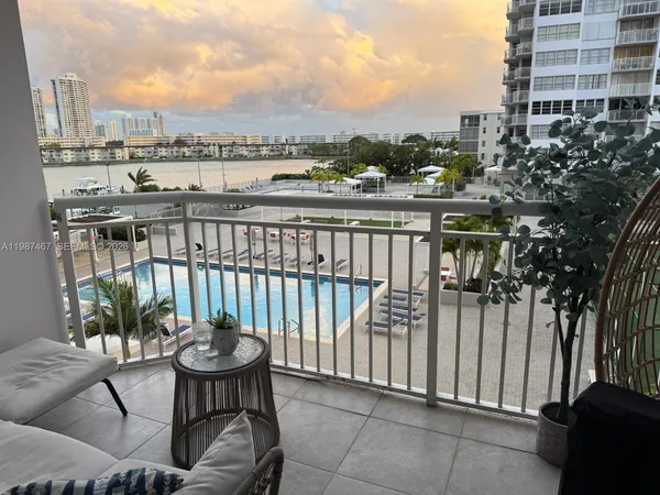 a view of a balcony with two chairs and a potted plant