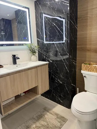 a bathroom with a toilet sink and mirror