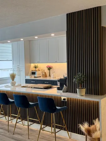 a kitchen with stainless steel appliances kitchen island granite countertop a table chairs and a large window