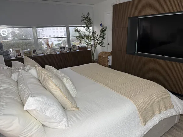 a bedroom with a bed and a flat screen tv