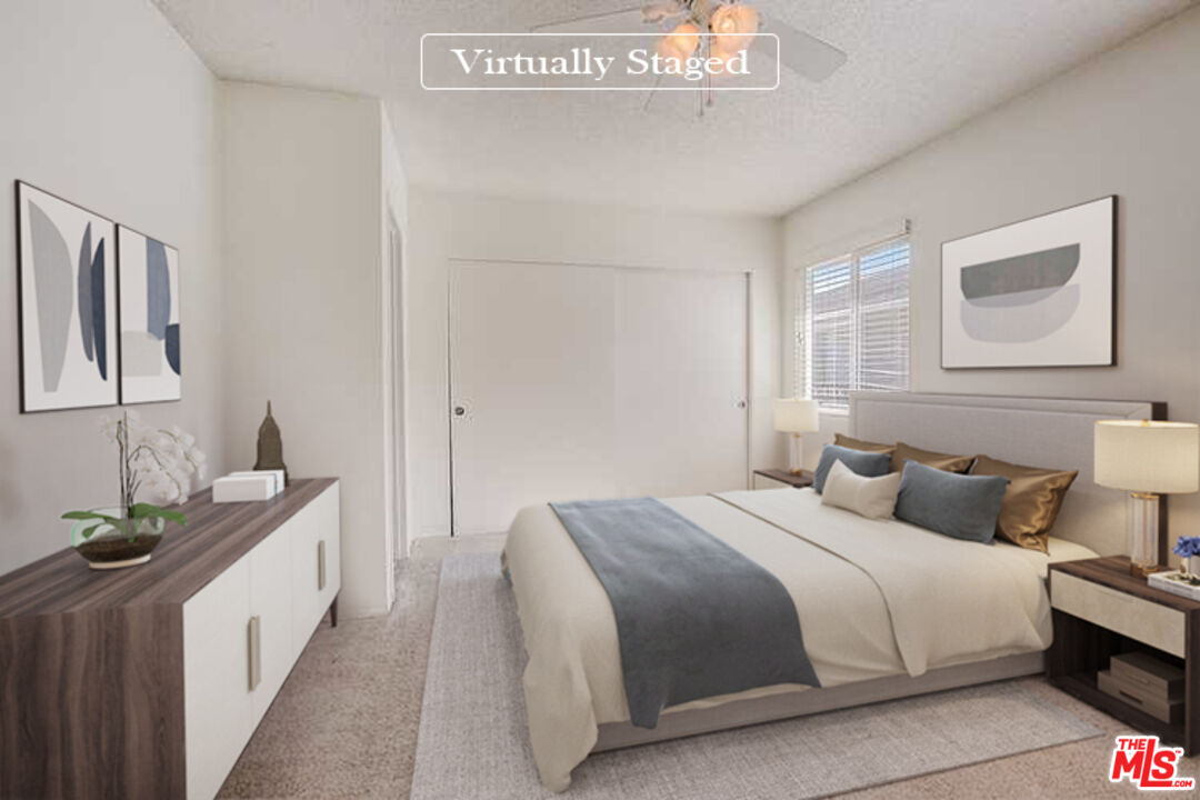 537 Spring Road, Unit 27 Moorpark, CA 93021 - Photo 3 of 30 a bedroom with a white bed and a night stand