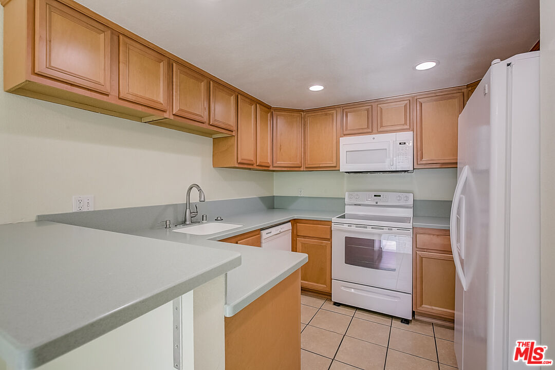 537 Spring Road, Unit 27 Moorpark, CA 93021 - Photo 4 of 30 a kitchen with stainless steel appliances granite countertop a sink stove and refrigerator