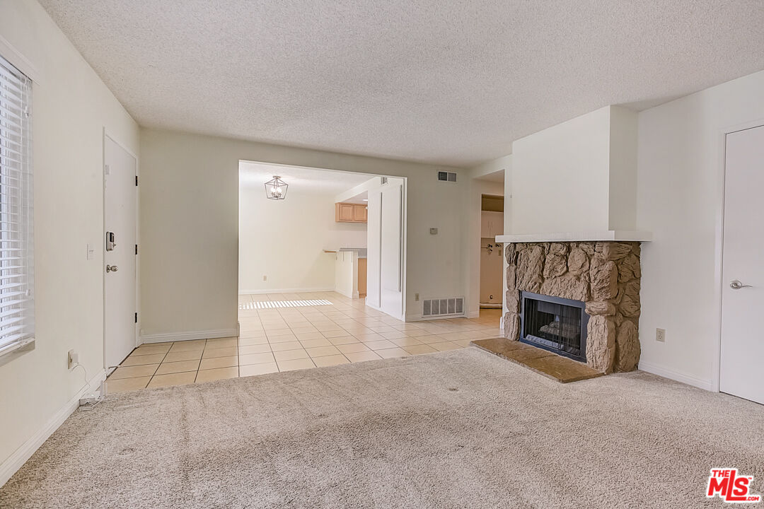 537 Spring Road, Unit 27 Moorpark, CA 93021 - Photo 6 of 30 an empty room with a fireplace and cabinet