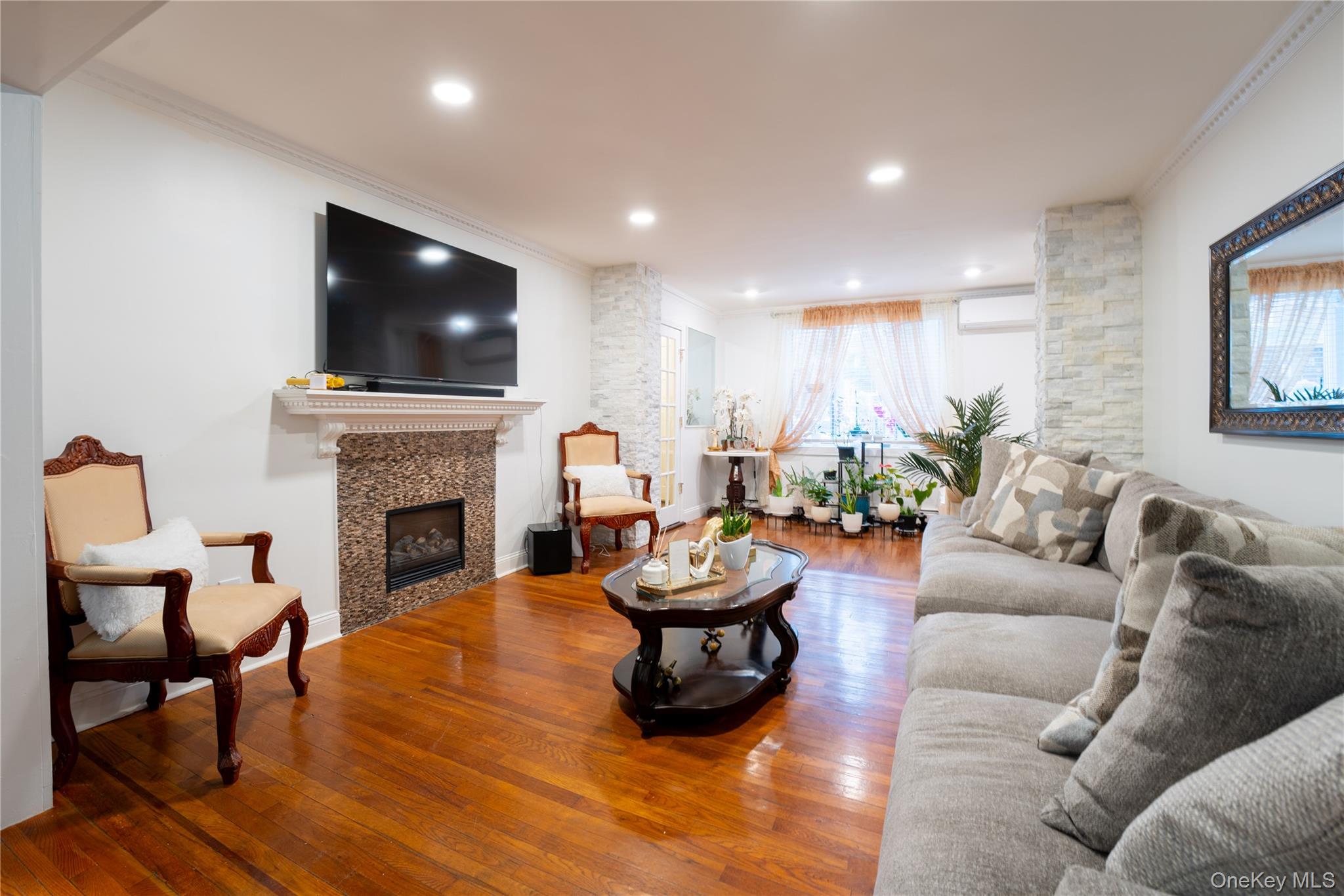 1925 Radcliff Avenue Bronx, NY 10462 - Photo 3 of 27 a living room with furniture a flat screen tv and a fireplace