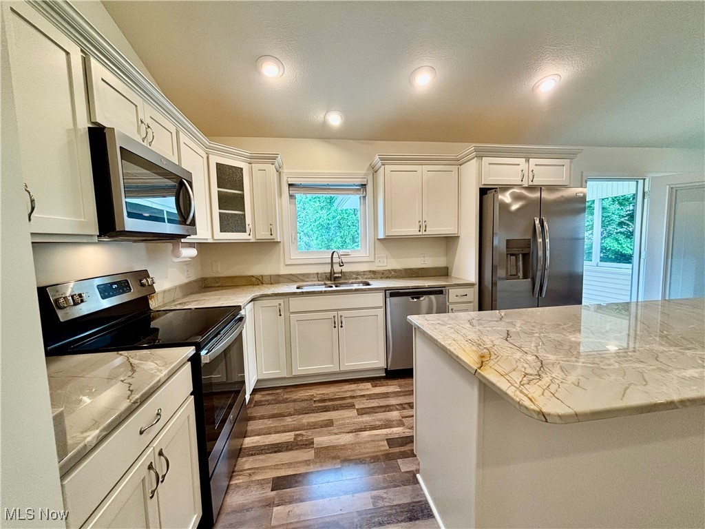1132 Hummingbird Way Findlay, OH 45840 - Photo 9 of 28 Kitchen featuring appliances with stainless steel finishes, wood finished floors, healthy amount of natural light, white cabinetry, and recessed lighting