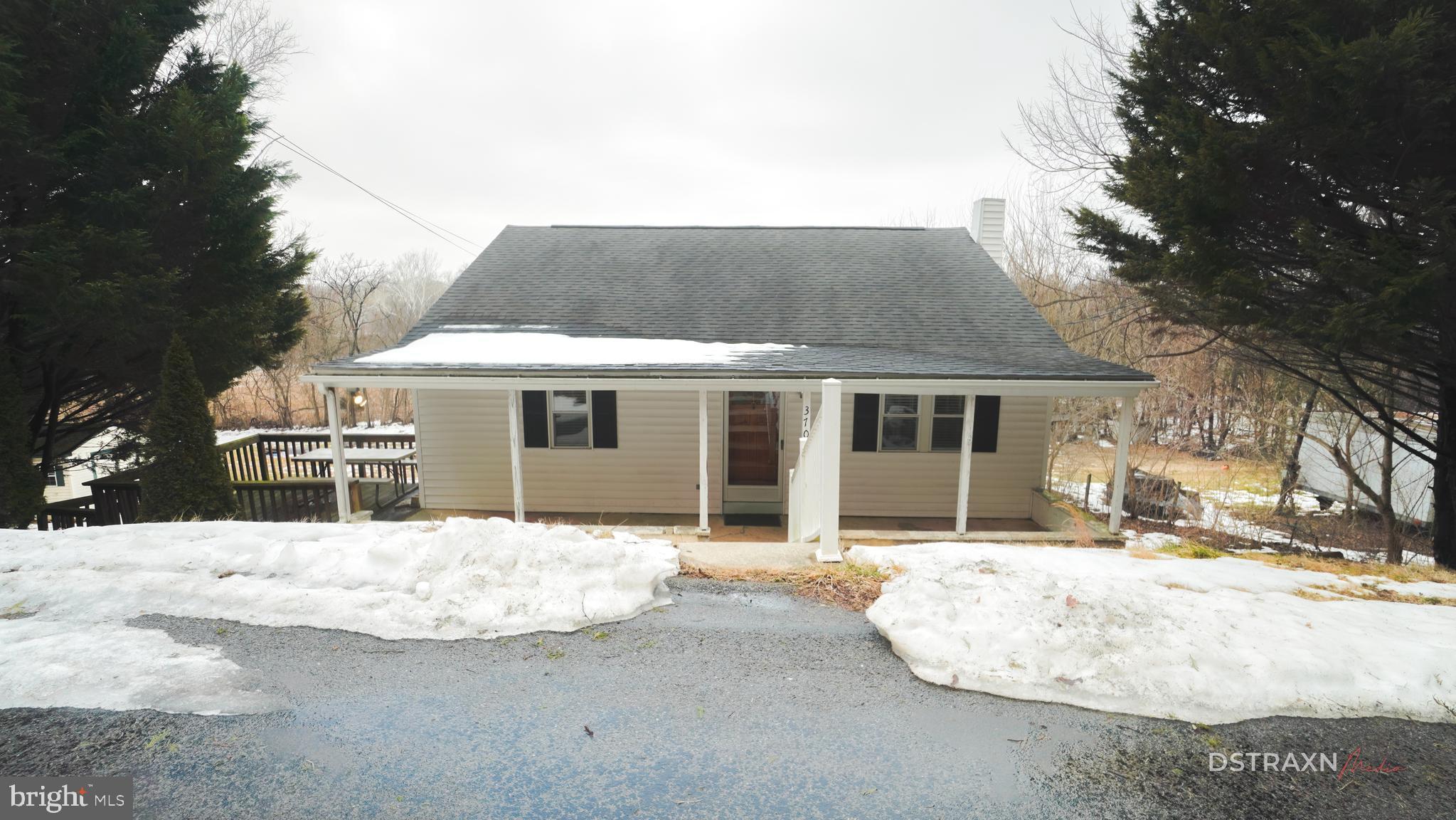 a front view of a house with a yard covered in snow