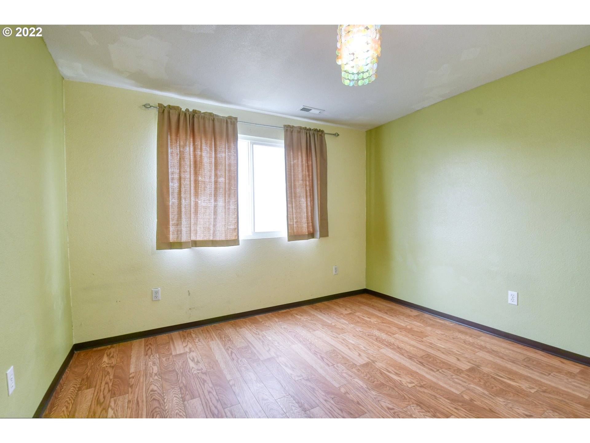 1816 Southwest 45th Street Pendleton, OR 97801 - Photo 22 of 32 an empty room with wooden floor and windows