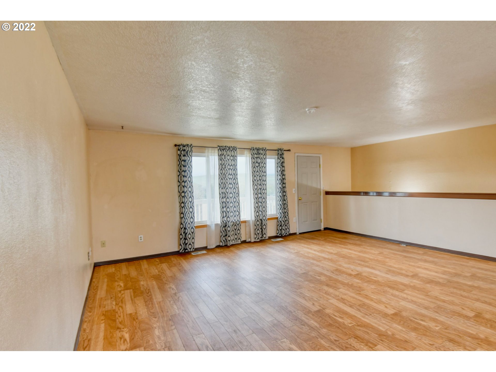 1816 Southwest 45th Street Pendleton, OR 97801 - Photo 3 of 32 a view of an empty room with wooden floor and a window